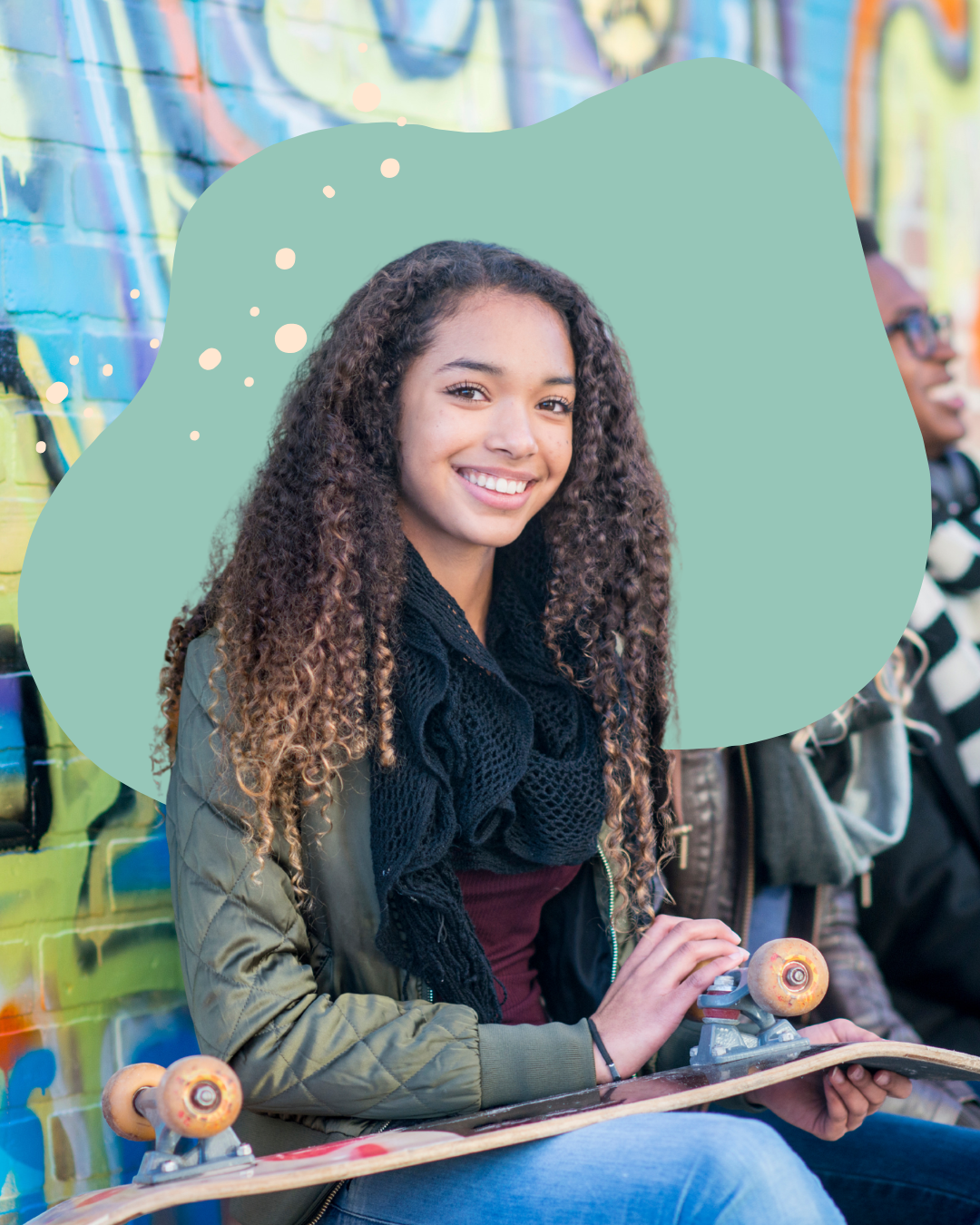 teen girl smiles holding skateboard